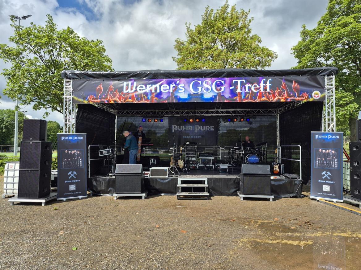 Outdoor-Bühne mit Banner Werners GSG Treff, Lautsprechern und Musik-Equipment